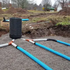 Arbetet med enskilt avlopp pågår. Grus och rör läggs ut för att hantera avloppsvatten, en viktig investering för framtiden.