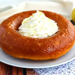 En gyllene baba, en klassisk dessert, toppas med fluffig grädde och citronskal. Perfekt för en fika!
