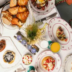 Un plateau de viennoiseries, tartes, œufs, jus et café pour un meilleur brunch parisien.