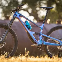 A stunning 2018 Cannondale Jekyll mountain bike with a iridescent blue frame, parked in golden hour light.