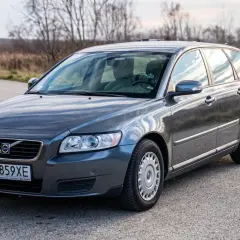 Szary Volvo V50 2.0D na drodze, otoczony jesienną przyrodą.