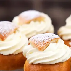 Fem fluffiga semlor med rikligt vispad grädde och pudrat florsocker. Perfekt för att baka egna semlor till fikat.