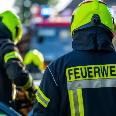 Feuerwehrleute in voller Montur, bereit für den Einsatz. Interessiert, wie viel verdient man als Feuerwehrmann netto?