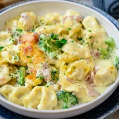 Cremiger Tortellini Auflauf mit Brokkoli und Schinken, überbacken mit Käse und bestreut mit Petersilie. Ein köstliches Gericht!