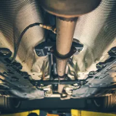 Sottoscocca di un'auto con tubo di scarico e filtro antiparticolato (FAP) visibili.