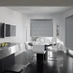 Tende antirumore funzionano: un elegante soggiorno con tavolo da pranzo apparecchiato e tende a rullo con motivo floreale che bloccano il rumore esterno.