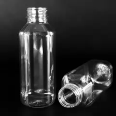 Dwie puste, przezroczyste butelki PET o pojemności 300 ml na czarnym tle. Jedna stoi pionowo, druga leży.