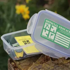 Pudełko z napisem "Official Geocache" i kompasem. To jest właśnie geocaching – zabawa w poszukiwanie skarbów.