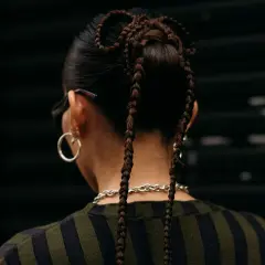 Peinados para conciertos: trenzas recogidas en forma de moño con dos coletas largas.