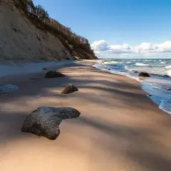 Plaża z klifem i kamieniami, fale Bałtyku. Wyobraź sobie, że to jedne z **polskich wysp na Bałtyku**, gdzie natura tworzy dzikie krajobrazy.