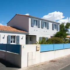 Maison année 70 rénovée, avec volets bleus et clôture assortie. Avant, elle était plus sombre.