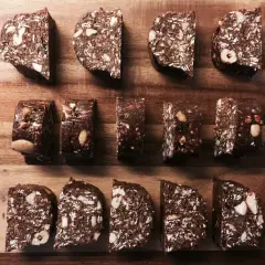 Chokladiga egna bars med nötter och kokos, upplagda på en träskärbräda.