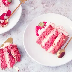 Pyszny tort z warstwami biszkoptu i puszystego kremu truskawkowego, ozdobiony świeżymi owocami.