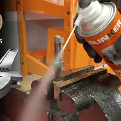 Guantes rociando un tornillo oxidado con un spray "Penetrating Oil + Ice" para ayudarte como aflojar tuercas y tornillos agarrotados oxidados o pegados.