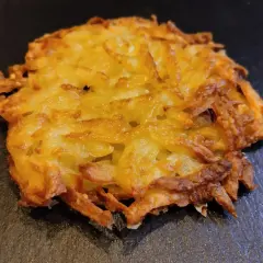 Un croccante rosti di patate dorato, preparato con patate grattugiate e cotto fino a ottenere una deliziosa crosticina.