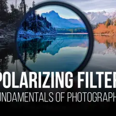 A polarizing filter enhances a landscape photo, reducing glare and deepening colors. The image shows a lake reflecting mountains and trees, with the filter in the foreground.
