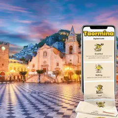 Taormina, Italia: una piazza storica illuminata al tramonto, con un'app guida digitale che mostra colazione, passeggiate e cibo locale.