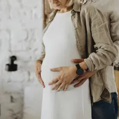 Para, obejmująca brzuch kobiety, czeka na dziecko. Po 16 dniach po porodzie można się kochać.
