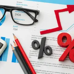 Kalkulator, okulary i wykresy sugerują analizę finansową, być może związaną z kredytem na samochód.