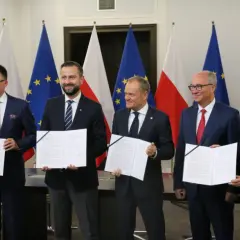 Pięciu mężczyzn w garniturach trzyma dokumenty. To tekst umowy koalicyjnej, symbol porozumienia.