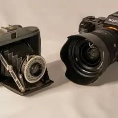 Stary aparat mieszkowy i nowoczesny aparat Sony obok siebie pokazują, jak działa aparat fotograficzny, od prostych mechanizmów po zaawansowaną elektronikę.