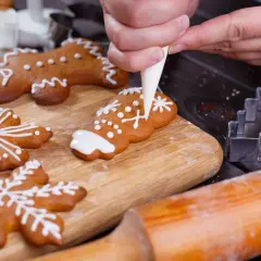 Ręcznie dekorowane pierniczki, w tym ludziki i płatki śniegu, z użyciem najprostszego lukru do pierników.