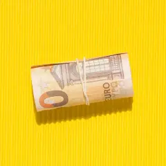 Zrolowana wiedeń waluta, banknot 50 euro, na żółtym, karbowanym tle.