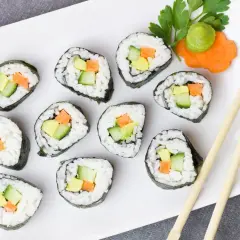 Talerz sushi z awokado, ogórkiem i marchewką. Czy sushi jest kaloryczne? Zależy od składników, ale te warzywne rolki wyglądają lekko!