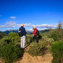 Un couple profite d'un week-end randonnée en amoureux, admirant le paysage montagneux sous un ciel bleu éclatant.