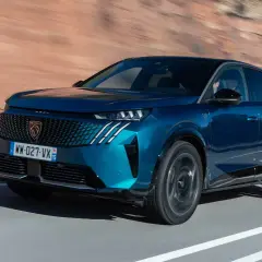 Blå Peugeot 3008 kör på en väg, redo för ett test.