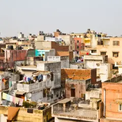 Gęsto zabudowane dachy w New Delhi, świadczące o dużej **new delhi ludność**. Widać pranie rozwieszone do suszenia i zbiorniki na wodę.