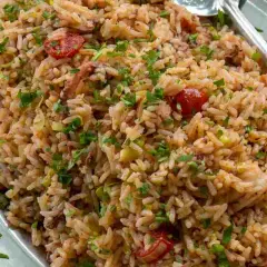 Un invitante insalata di riso di mare, ricca di pomodorini, erbe aromatiche e pezzi di pesce, pronta per essere gustata.