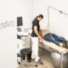 Ärztin untersucht Patienten auf Liege. Ein Ultraschallgerät steht bereit. Was tut dem Herz gut? Diese Behandlung.