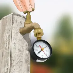 Mano girando la llave de un grifo de latón conectado a un manómetro que mide la presión en el agua.