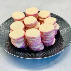 En hög med rosa och gula brysselkex på en svart tallrik. Perfekt för ett brysselkex recept!
