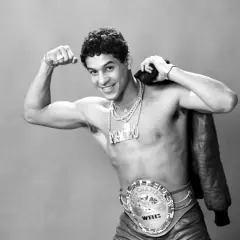 Boxaren Hector Camacho poserar stolt med sitt WBC-mästarbälte och en läderjacka över axeln.
