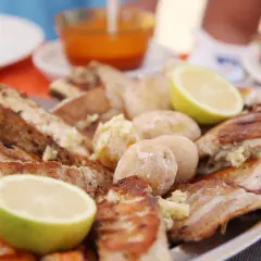 En stor tallrik med grillad fisk, potatis och citronklyftor. En härlig måltid som påminner om en marknad på Gran Canaria.
