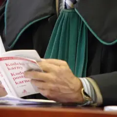 Prawnik w todze czyta Kodeks karny.