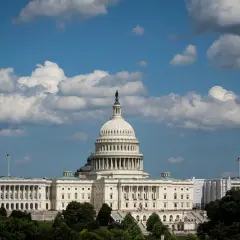 The U.S. Capitol building under a cloudy sky. Members of Congress work within these walls, but do members of Congress have security clearances?