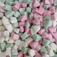 En hög med Ahlgrens bilar fluff i rosa, vitt och grönt. De ser mjuka och fluffiga ut, redo att ätas.