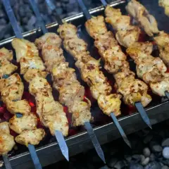 Kebab z mięsa mielonego na patyczkach grilluje się nad żarem. Mięso jest soczyste i apetyczne.