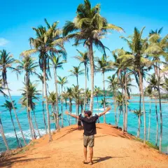 Wspaniałe widoki na Sri Lankę, idealne na loty. Człowiek wita się z rajską plażą i palmami.