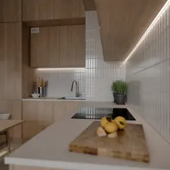Nowoczesna biała kuchnia z drewnianym blatem, który pięknie komponuje się między szafkami. Na blacie cytryny i deska do krojenia.
