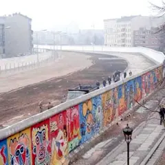 Kolorowy Mur Berliński, świadectwo czasów, kiedy wzniesiono mur berliński, z ludźmi spacerującymi po chodniku.