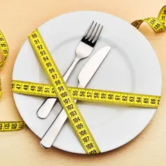 Une assiette avec couverts est entourée d'un mètre ruban jaune. La question "quel poids pour 1m60 femme" est implicite.