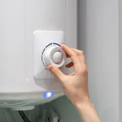 Dłoń reguluje pokrętłem maksymalną temperaturę wody w bojlerze.