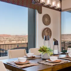 A rustic wooden dining table set for a meal, with a stunning view of a desert landscape. This image inspires how to choose a dining room table for a scenic setting.