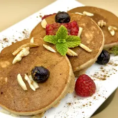 Pancake farina di castagne con lamponi, mirtilli, mandorle e menta. Un dolce autunnale invitante.