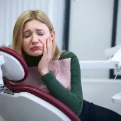 Dziewczyna w gabinecie dentystycznym cierpi z powodu silnego bólu zęba. Potrzebuje pilnej pomocy lek.