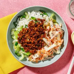 En skål med ris, grönsaker och en kryddig topping. Ett gott kålrabbi recept som ser aptitligt ut.